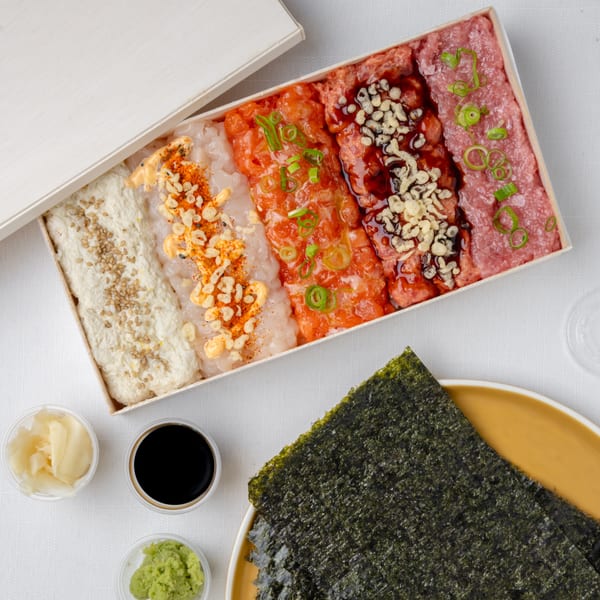 Temakase sushi hand roll kit with various fish, sauces, nori, ginger, wasabi, and soy sauce.